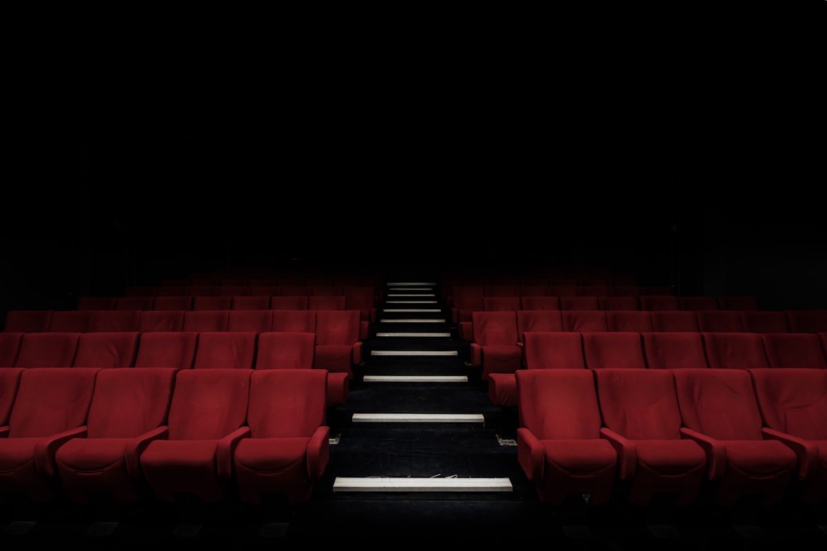 Dark cinema hall with red seats for a movie premiere