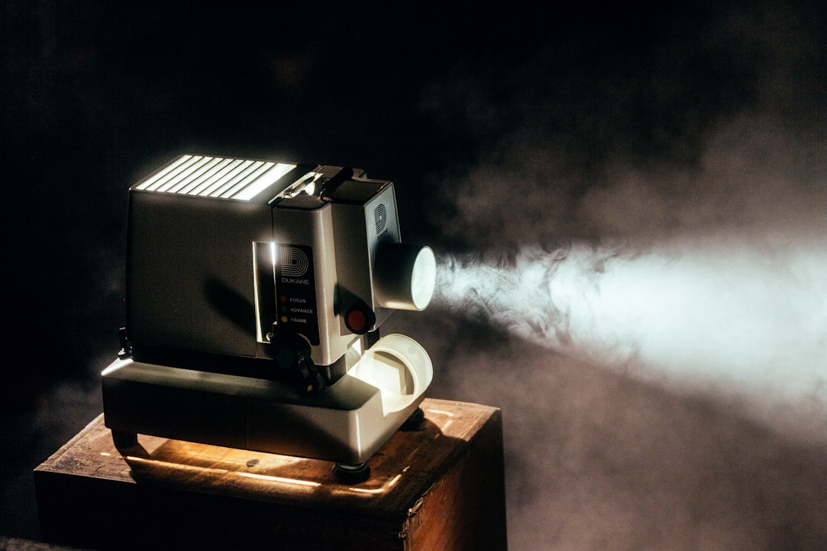 Vintage film projector casting light in a dark room
