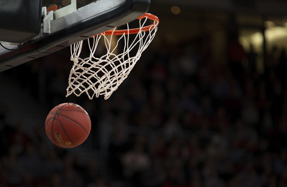 Basketball dropping through the hoop in a packed arena